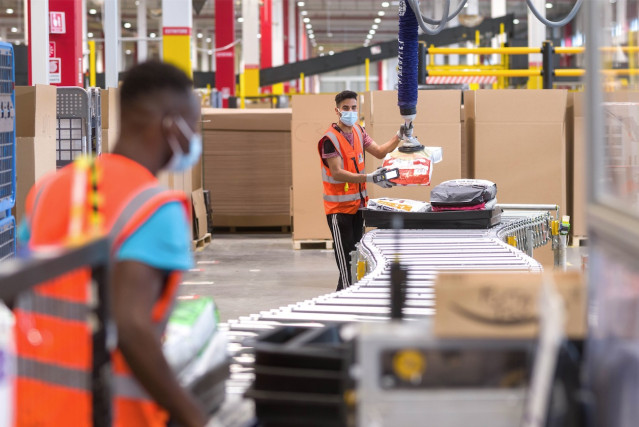 Un empleado de Amazon utiliza una máquina de precintado automática