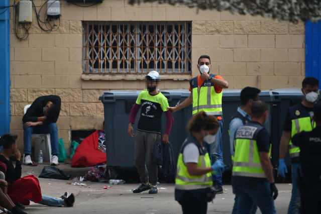 Agentes de la Policía Nacional acompañan a menores marroquíes a las naves acondicionadas anexas a la frontera del Tarajal