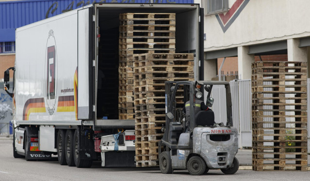 Archivo - Un hombre trabaja transportando palés en el Polígono Industrial del madrileño barrio de Vallecas
