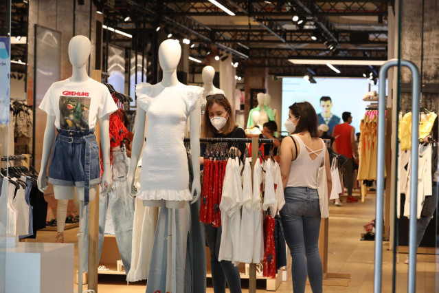 Archivo - Personas con mascarilla en el interior de una tienda de ropa en el primer día de la fase 1 en Madrid