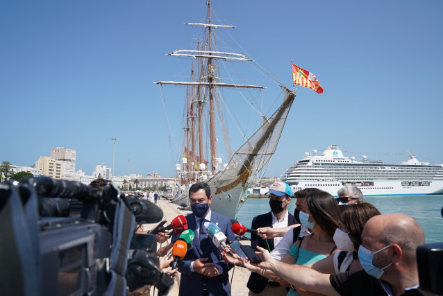 Juanma Moreno atiende a los medios de comunicación tras la recepción al Buque-Escuela Juan Sebastián Elcano en Cádiz.