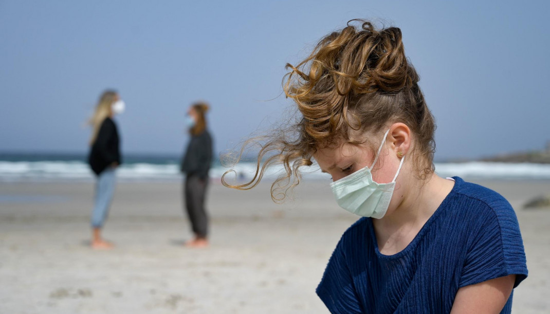 Archivo - Una niña con mascarilla en la playa.