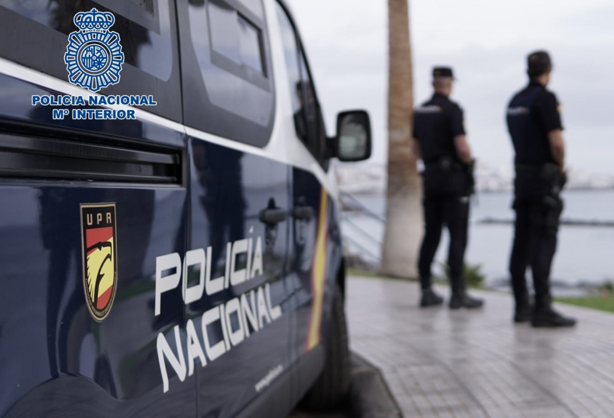 Archivo - Agentes de la Policía Nacional junto a un coche patrulla