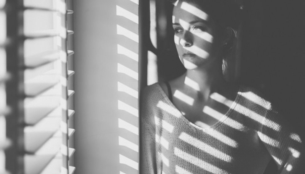 Archivo - Mujer con deprensión frente a la ventana en su casa. Confinamiento, salud mental. Covid-19