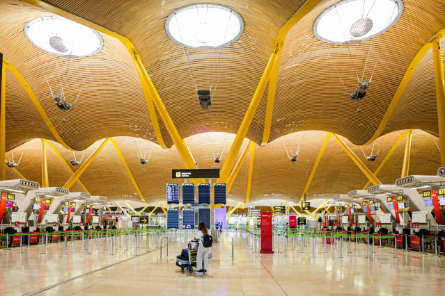Archivo - Una turista observa los paneles de la Terminal 4 del Aeropuerto Adolfo Suárez-Madrid Barajas