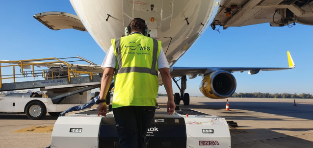 Imagen de un operario de WFS dirigiendo el nuevo ‘pushback’ mientras remolca una aeronave