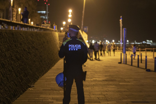 Archivo - Un agente de Policía vigila la playa de la Barceloneta durante el primer viernes sin toque de queda, a 14 de mayo de 2021, en Barcelona, Catalunya, (España). Este es el primer viernes sin toque de queda donde se han vuelto a repetir las imágenes