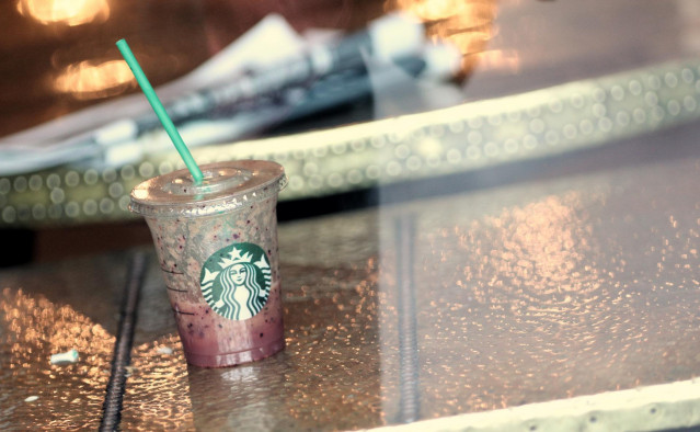 Archivo - Vaso de plástico con pajita en una de las cafeterías que tiene la compañía americana Starbucks en Madrid (España), a 24 de septiembre de 2019. E