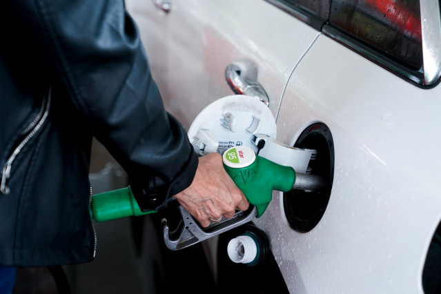 Archivo - Una mujer pone gasolina a su vehículo en una gasolinera