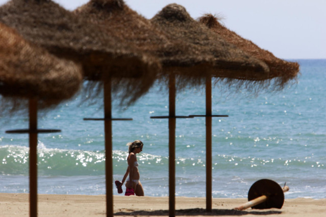 Archivo - Paseantes disfrutan de la playa de Sacaba en la barriada de Huelín