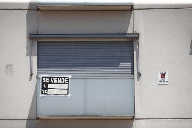 Archivo - Cartel de 'se vende' en el balcón de un piso de un edificio de Madrid.