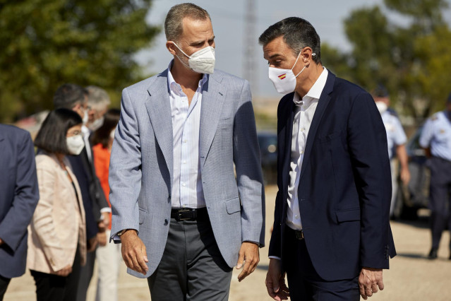 El Rey Felipe VI (i) y el presidente del Gobierno, Pedro Sánchez, conversan a su llegada al Pabellón de Cuadros de Mando de la Base Aérea de Torrejón donde han acudido para visitar el dispositivo provisional en Torrejón de Ardoz