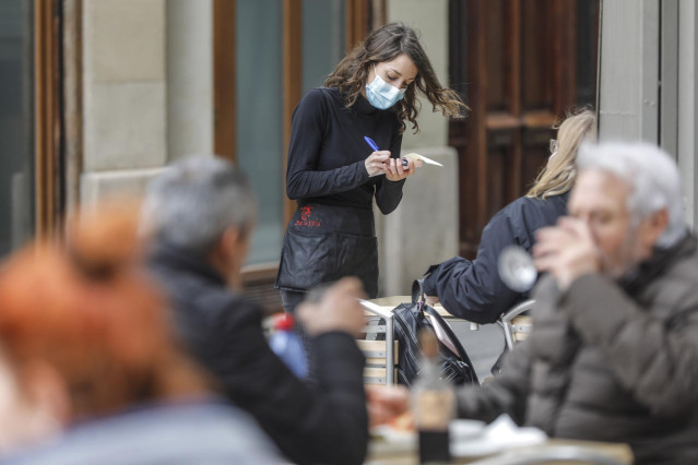 Archivo - Una camarera atiende a varios clientes en una terraza el primer día de la apertura de la hostelería en Valencia, Comunidad Valenciana (España), a 1 de marzo de 2021. Coincidiendo con el inicio de la desescalada en la región, la hostelería de la