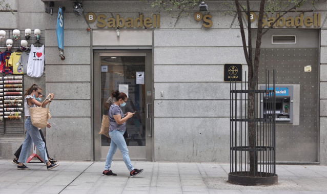 Varias personas pasan por una sucursal de Banco Sabadell, a 2 de septiembre de 2021, en Madrid (España).