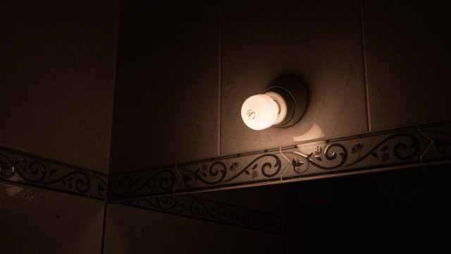 Una lámpara encendida en el interior de una casa