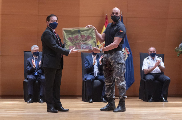 Un policía del Grupo Especial de Operaciones (GEO) entrega al ministro de Asuntos Exteriores, José Manuel Albares, la bandera nacional que ondeaba en la Embajada de Kabul