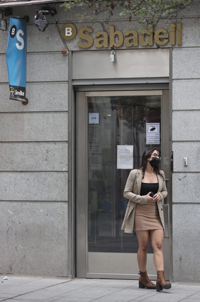 Una mujer sale de una sucursal de Banco Sabadell