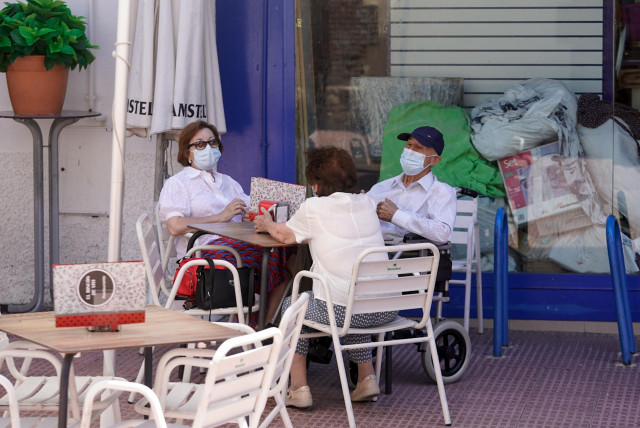 Archivo - Ancianos con mascarilla conversan sentados en la terraza de un bar, a 27 de julio de 2021, en Madrid, (España).