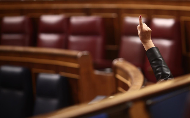 Archivo - Un miembro del hemiciclo vota durante una sesión plenaria celebrada en el Congreso