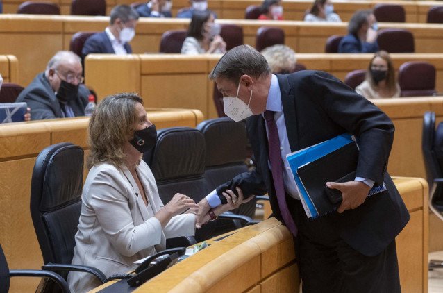 La vicepresidenta tercera y ministra de Transición Ecológica y Reto Demográfico, Teresa Ribera, mantiene una conversación con el ministro de Agricultura, Pesca y Alimentación, Luis Planas, durante un Pleno del Senado, el primero tras el parón estival