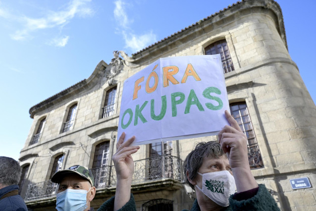 Archivo - Una persona sostiene un cartel donde se puede leer 
