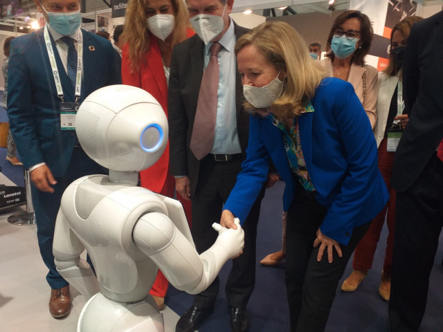 La vicepresidenta del Gobierno y ministra de Asuntos Económicos y Transición Digital, Nadia Calviño, 'saluda' a un robot, durante su visita a la feria Mindtech 2021 en Vigo.