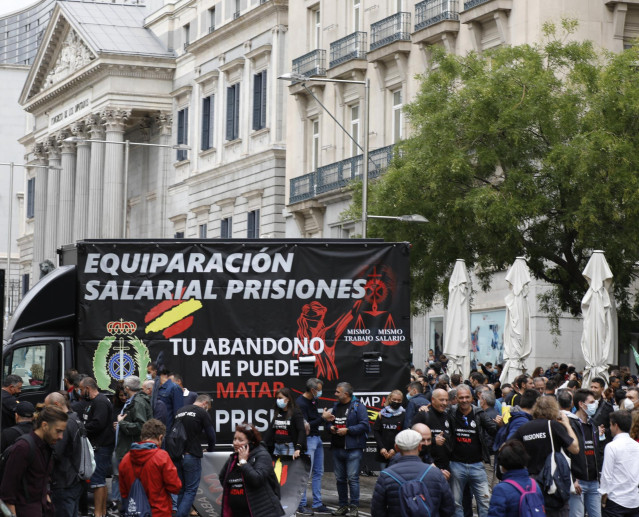 Varios funcionarios de prisiones junto a un furgón de la asociación Tu Abandono Me Puede Matar durante una manifestación por la equiparación salarial en el Congreso
