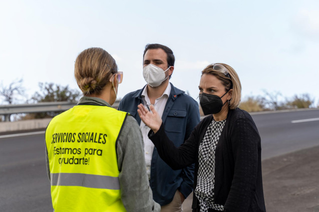 El ministro de Consumo, Alberto Garzón, y la consejera de Derechos Sociales del Gobierno de Canarias, Noemí Santana, conversan con una trabajadora de servicios sociales durante una visita al acuartelamiento de 'El Fuerte'