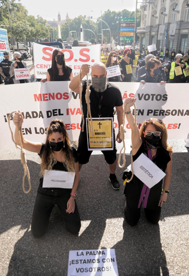 Varias personas sostienen pancartas durante una protesta organizada por las asociaciones y colectivos de La Alianza Empresarial por la Bajada del IVA a la Imagen Personal, a 27 de septiembre de 2021, en Madrid, (España). Las federaciones, asociaciones, pl