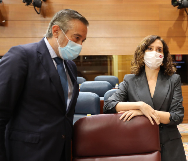 El consejero de Presidencia, Justicia e Interior de la Comunidad de Madrid, Enrique López, conversa con la presidenta de la Comunidad de Madrid, Isabel Díaz Ayuso.