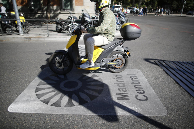 Archivo - Una moto pasa por encima de una señal de Madrid Central que indica restricciones al tráfico en el centro de la capital