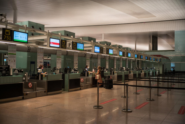 Archivo - Una pasajera acude a los mostradores de las aerolíneas del Aeropuerto Josep Tarradellas Barcelona-El Prat.