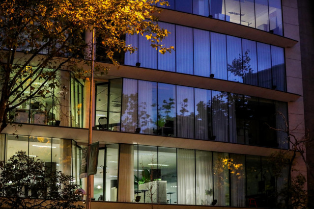 Archivo - Un edificio de oficinas con las luces encendidas