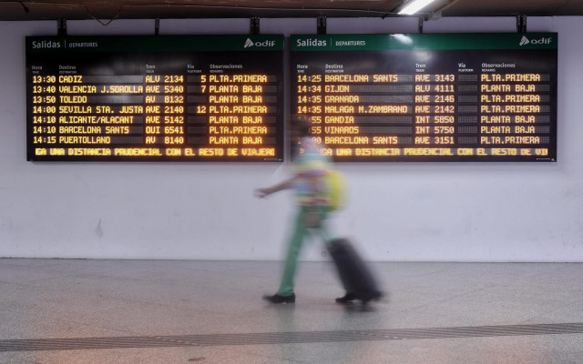 Archivo - Una mujer camina por un pasillo de la estación de Atocha