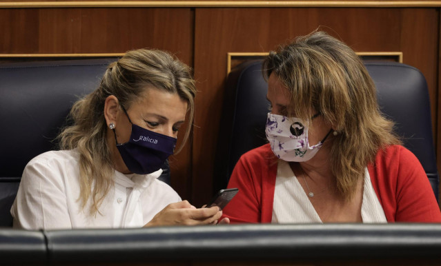 La vicepresidenta segunda del Gobierno y ministra de Trabajo, Yolanda Díaz (i), y la ministra de Transición Ecológica, Teresa Ribera (d), conversan en una sesión plenaria en el Congreso