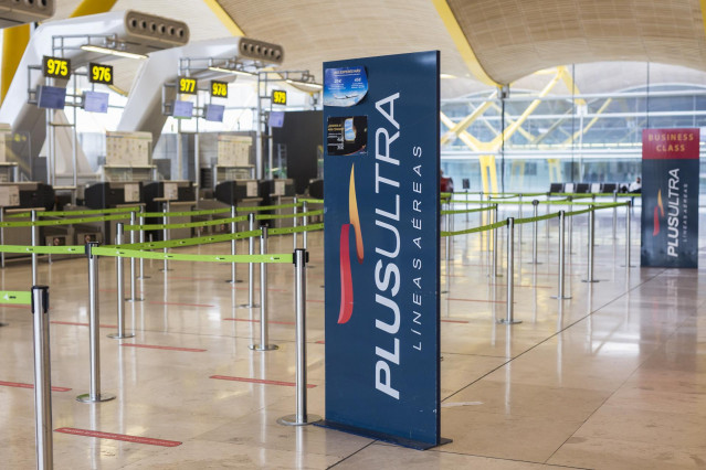 Archivo - Un panel muestra información sobre vuelos de la aerolínea Plus Ultra, en el aeropuerto de Madrid.