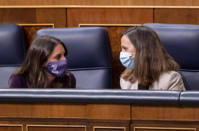 La ministra de Igualdad, Irene Montero (i), y la ministra de Derechos Sociales y Agenda 2030, Ione Belarra, conversan en una sesión plenaria en el Congreso de los Diputados, a 14 de octubre de 2021, en Madrid, (España). El pleno tiene como objeto abordar