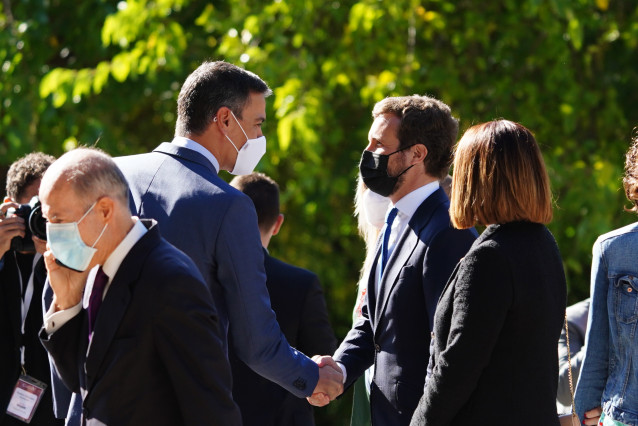 El presidente del Gobierno, Pedro Sánchez, saluda al lider del PP, Pablo Casado, a su llegada al Real Monasterio de Yuste para asistir a la entrega el 'Premio Europeo Carlos V a la canciller alemana, Angela Merkel, a 14 de octubre de 2021.