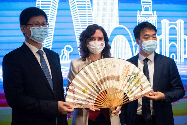 (I-D) El presidente de Huawei Europa, Li Peng; la presidenta de la Comunidad de Madrid, Isabel Díaz Ayuso y el presidente y CEO Huawei España, Eric Li, posan con un abanico que la presidenta de la Comunidad de Madrid, ha recibido como muestra de agradecim