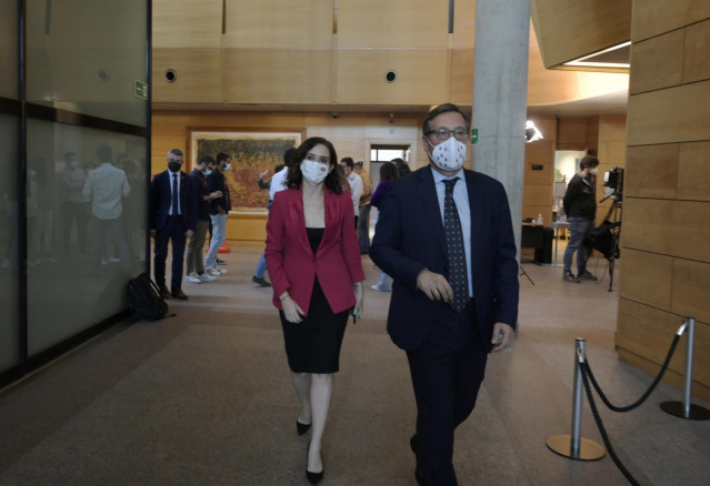 La presidenta de la Comunidad de Madrid, Isabel Díaz Ayuso (i), y el portavoz del PP, Alfonso Serrano (d), en la Asamblea de Madrid, a 21 de octubre de 2021, en Madrid, (España). El Pleno de la Asamblea de Madrid vuelve a centrar el debate en el Proyecto