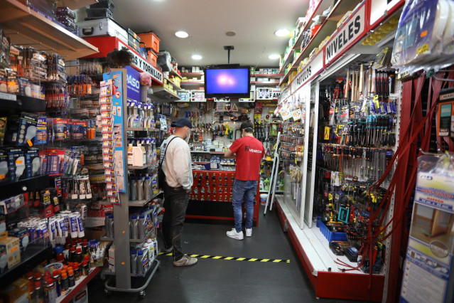 Archivo - Un dependiente atiende a un cliente en la Ferretería Venecia
