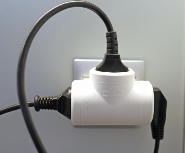 Varios cables conectados a un 'ladrón' en un enchufe