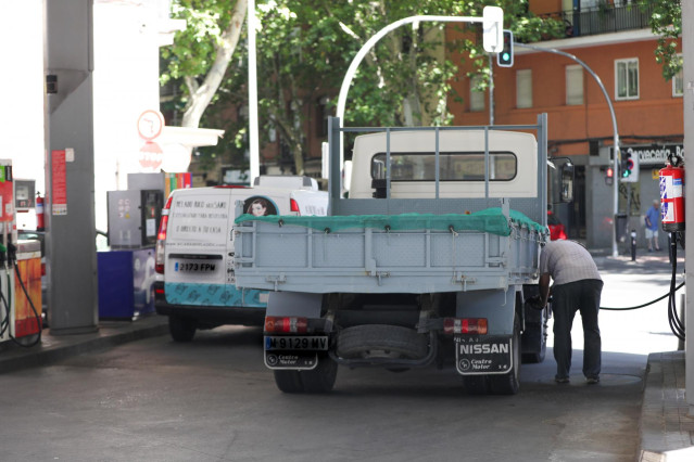 Archivo - Personas ponen gasolina en sus coches en una gasolinera de Madrid.