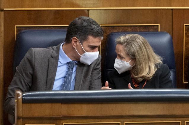 El presidente del Gobierno, Pedro Sánchez, y la vicepresidenta primera y ministra de Asuntos Económicos, Nadia Calviño, conversan en una sesión plenaria en el Congreso