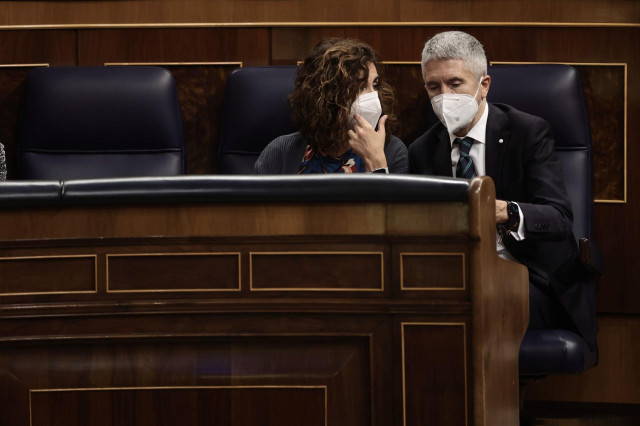 La ministra de Hacienda, María Jesús Montero, y el ministro del Interior, Fernando Grande-Marlaska, conversan en la sesión plenaria en el Congreso