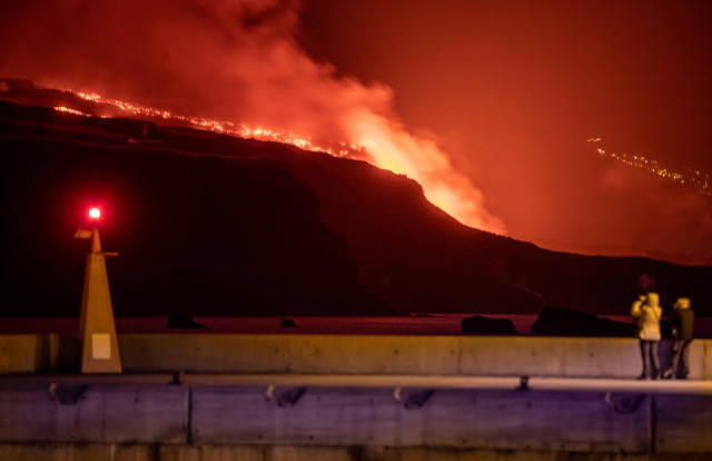Varias personas observan la lava y piroclastos a su llegada a la playa de los Guirres, a 9 de noviembre de 2021, en La Palma, Santa Cruz de Tenerife, Canarias, (España). La lava procedente del volcán de La Palma continúa fluyendo sobre coladas previas de