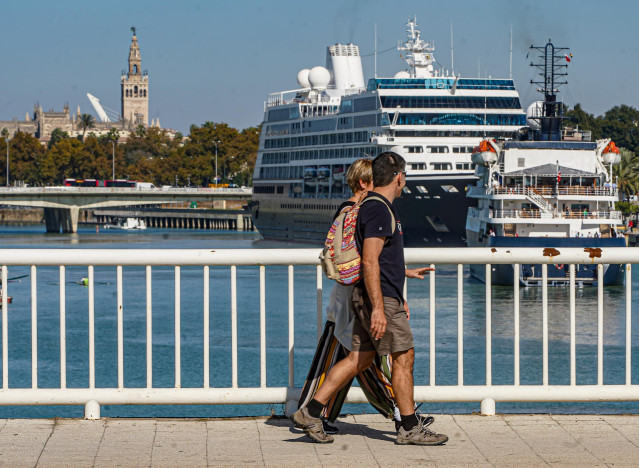 Dos turistas  observan la entrada de los Cruceros 'Azamara Quest' y 'Hebridean Sky' a el Puerto de Sevilla a 10 de noviembre del 2021 en Sevilla (Andalucía)