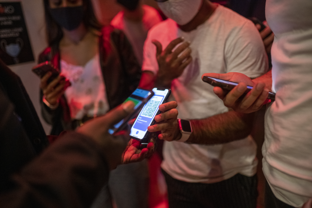 Archivo - Una persona muestra un código QR para entrar a un local de ocio nocturno la misma noche en que entra en vigor la reapertura en interiores a medianoche, a 8 de octubre de 2021, en Barcelona, Cataluña (España). Este viernes de madrugada vuelve a a