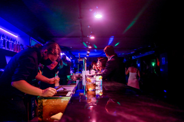 Archivo - Varias personas en la barra de una discoteca