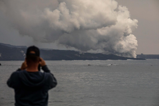 Una persona fotografía una columna de gases de la tercera colada que llega al mar desde el puerto Tazacorte, a 16 de noviembre de 2021, en La Palma, Santa Cruz de Tenerife, Canarias, (España).